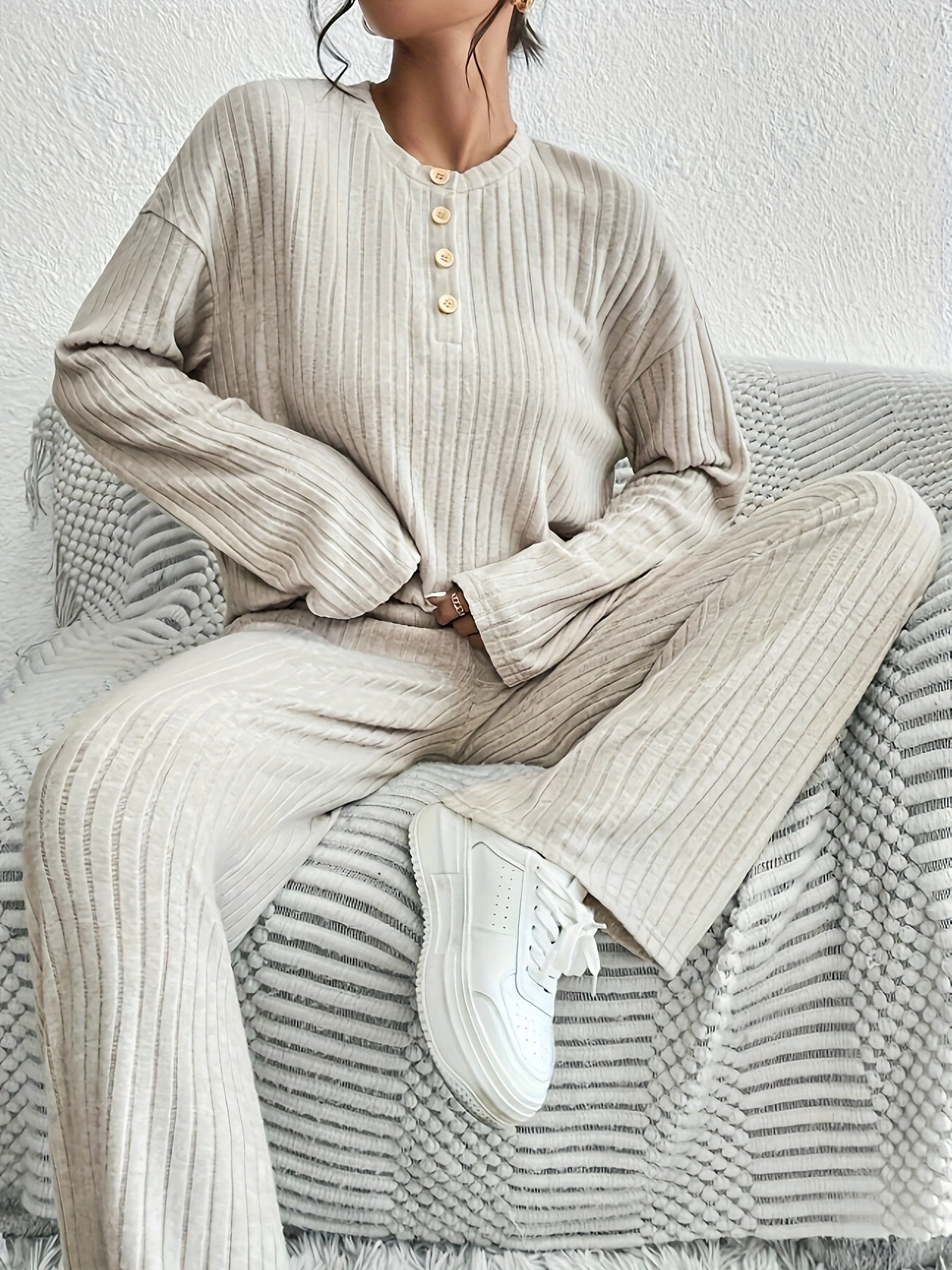 Представляем нашу новую коллекцию осень/зима для женщин: стильный комплект из двух предметов с длинными рукавами, текстурированным однотонным цветом, фальшивыми пуговицами и рифлеными спущенными плечами для повседневного образа.