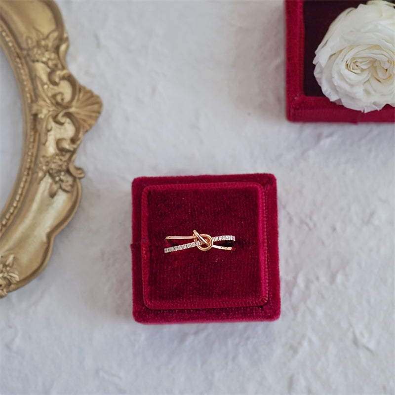 Ushbu ajoyib uzuk zamonaviy tugun dizayniga ega bo'lib, 925 sterling kumushdan tayyorlangan va porloq kubik zirkoniy aksentlari bilan bezatilgan. Bu sizning hayotingizdagi har qanday maxsus ayol uchun mukammal sovg'a.