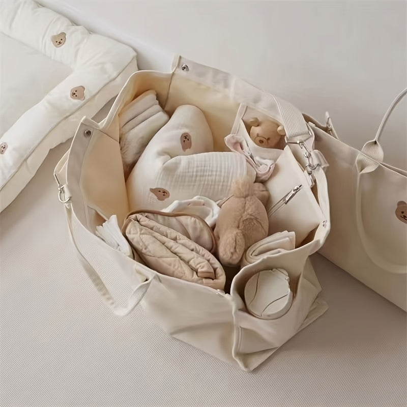 Zarif ayiq mavzusidagi to'plam sumkasi, mustahkam polyesterdan tayyorlangan, tozalash oson va oq rangda, pampers va kundalik zaruriy buyumlarni tashish uchun ideal.